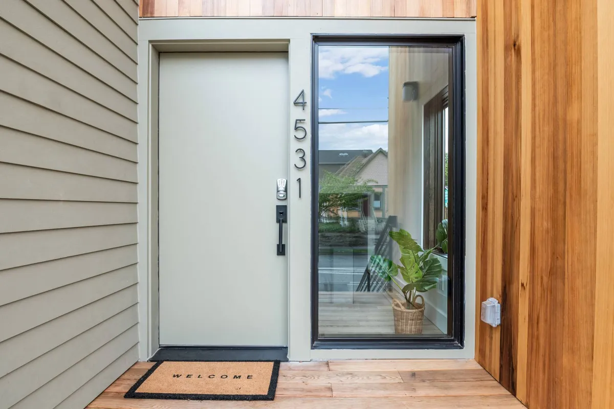 A warm and welcoming exterior view of the front door, complete with a welcome mat, a large window, and a potted plant. This entry scene suggests privacy and a sense of arrival, setting the tone for exclusive access and peaceful boundaries.