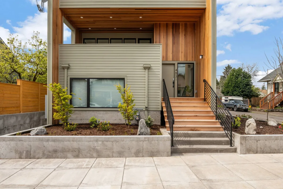 A close-up of the property’s welcoming wooden steps leading to the front door, complemented by a lush landscaped garden. The image captures intimate moments of arrival and quiet enjoyment of the outdoor space, underscoring the connection between home and neighborhood.