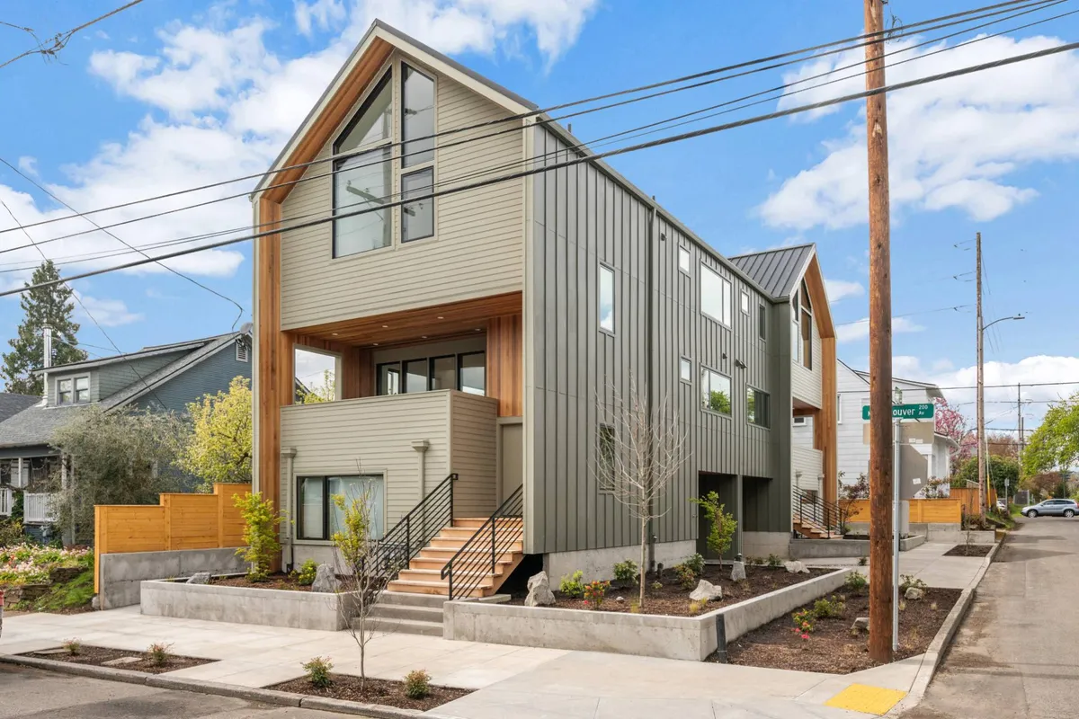This exterior image highlights the modern architectural design of the property, featuring inviting wooden accents, a landscaped front yard, and a staircase leading to the entrance. The scene suggests an active, social environment, perfect for gathering with friends or exploring the surrounding walkable neighborhood.